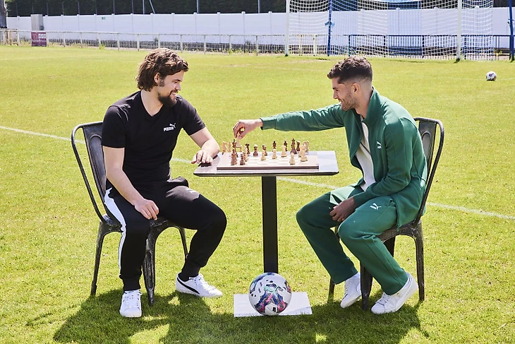 PUMA ambassadors Carlsen and Pulisic playing chess. Photo: PUMA.